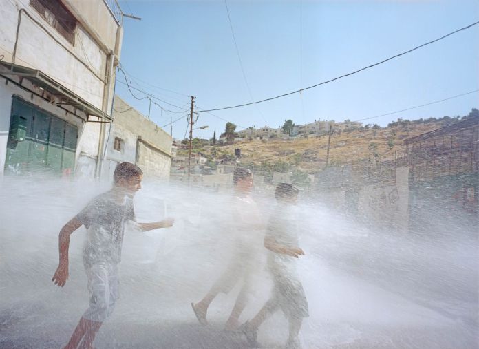 Ragazzini palestinesi si rinfrescano nel villaggio di Silwan, a Gerusalemme Est (foto di Gilles Peress)