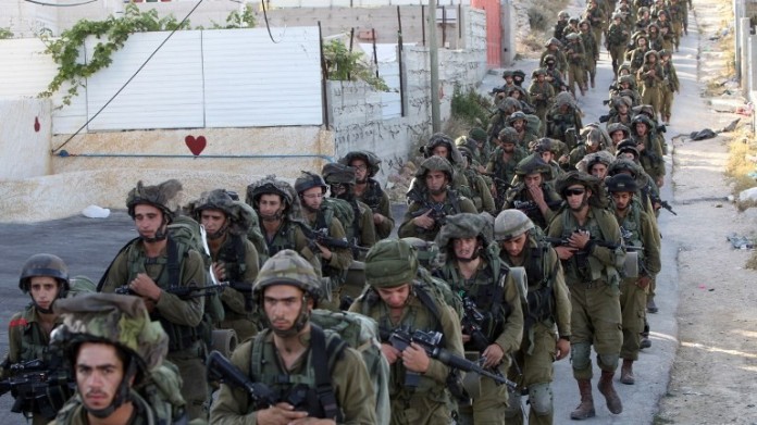 Centinaia di soldati israeliani per le vie di Hebron, in Cisgiordania, alla ricerca dei tre giovani rapiti (foto di Hazem Bader/Afp)